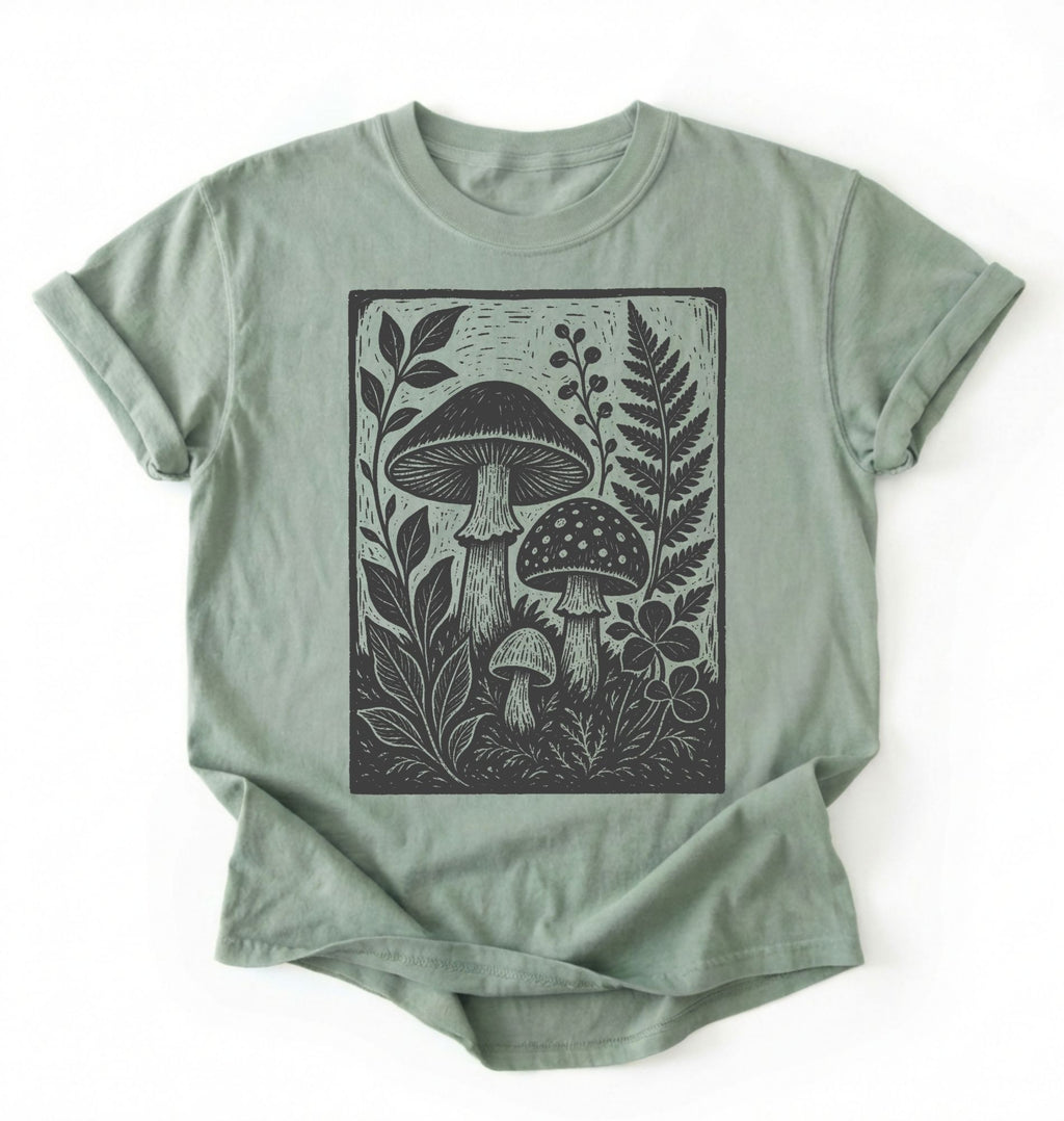 Flat lay of an light green vintage mushroom shirt green botanical fungi t shirt nature lover gift forest aesthetic design on a white background 