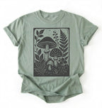 Flat lay of an light green vintage mushroom shirt green botanical fungi t shirt nature lover gift forest aesthetic design on a white background 