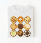 A white short-sleeve crewneck t-shirt featuring a graphic print of nine different mini pies arranged in a 3x3 grid, displayed flat against a white background.