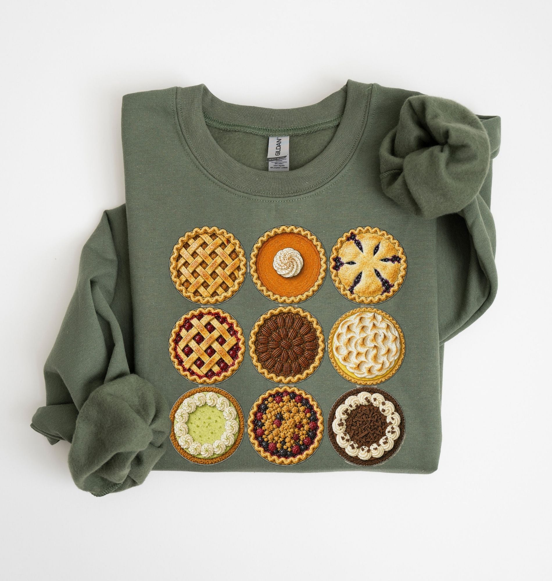 An olive green crewneck sweatshirt featuring a graphic of nine embroidered-style pies arranged in a 3x3 grid on the front. The sleeves are folded back, creating a ruffled look, and the sweatshirt is laid flat on a clean white background.