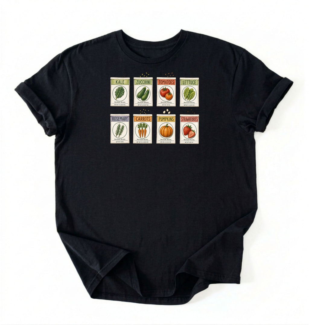 Flat lay of a black vintage seed packet garden shirt with heirloom vegetable and herb illustrations gardener gift on a white background