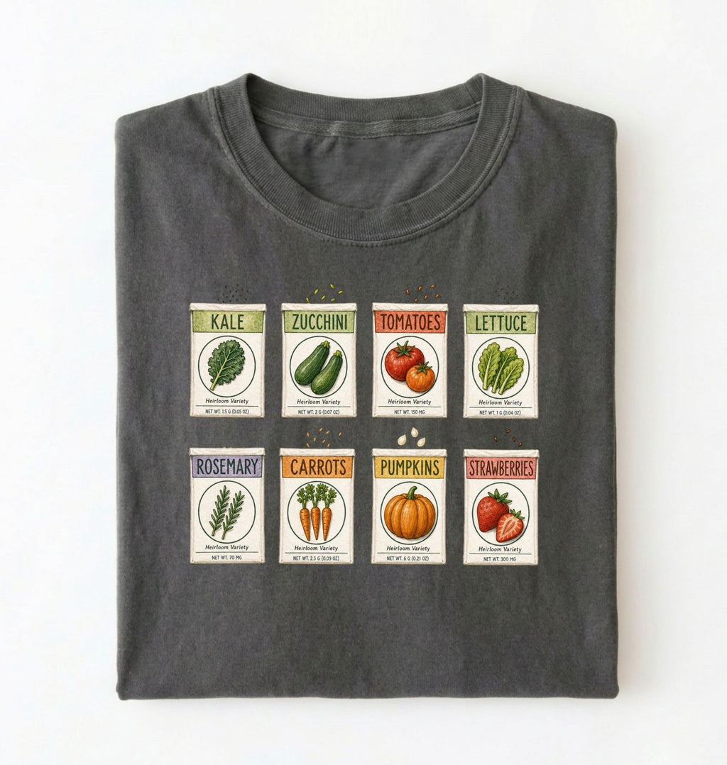 Flat lay of a moss vintage seed packet garden shirt with heirloom vegetable and herb illustrations gardener gift on a white background
