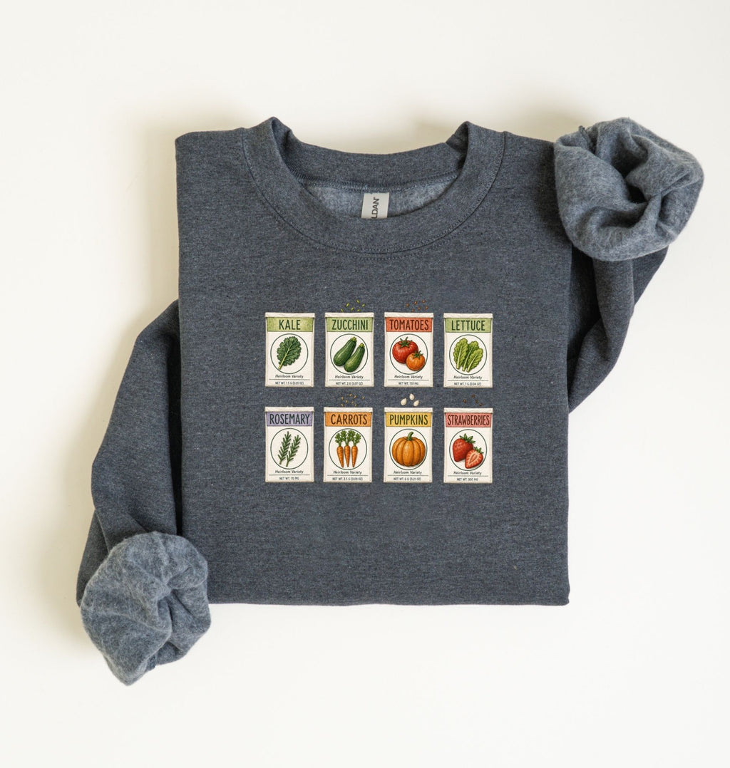 Flat lay of an dark heather vintage seed packet garden sweatshirt with heirloom vegetable and herb illustrations gardener gift on a white background 
