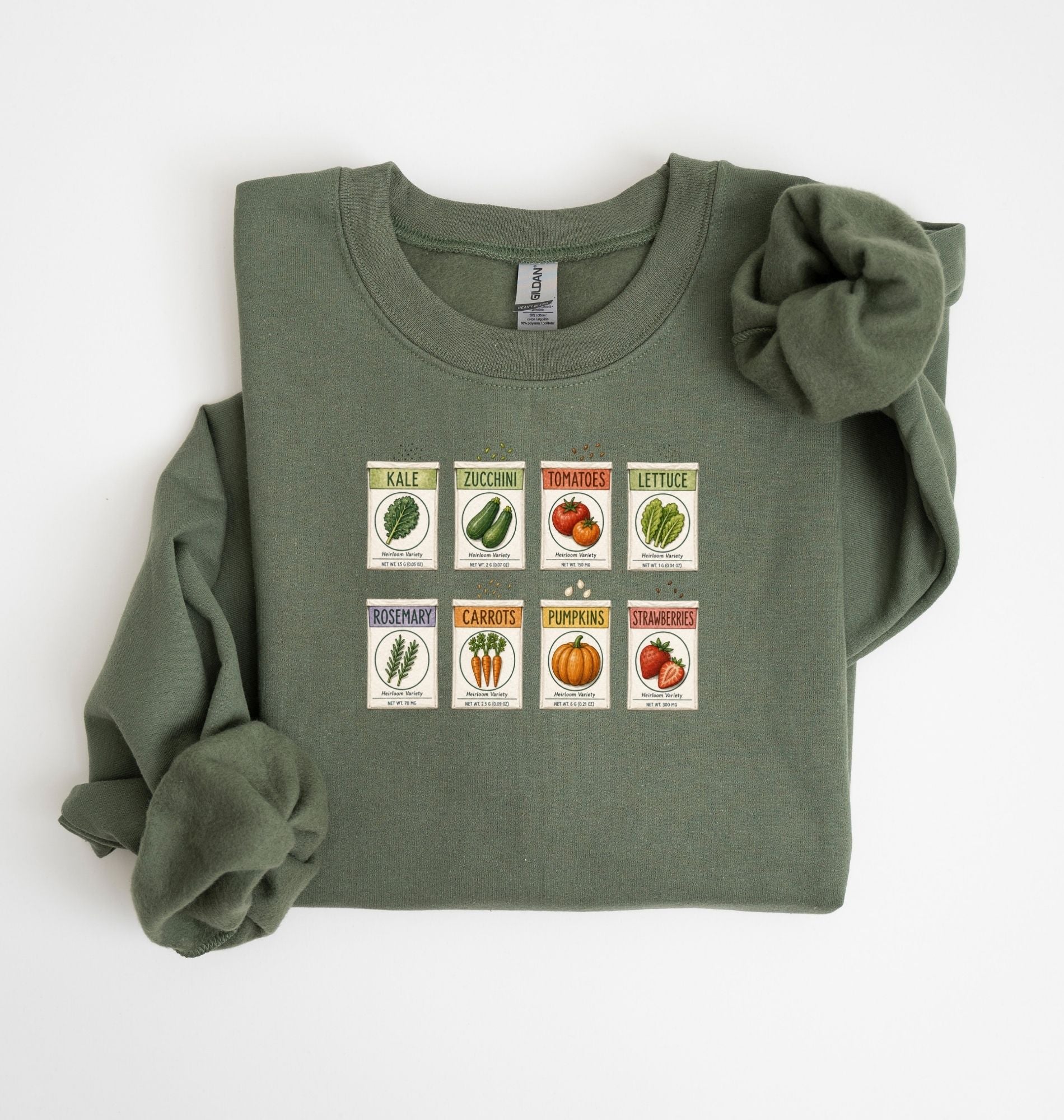 Flat lay of an green vintage seed packet garden sweatshirt with heirloom vegetable and herb illustrations gardener gift on a white background 