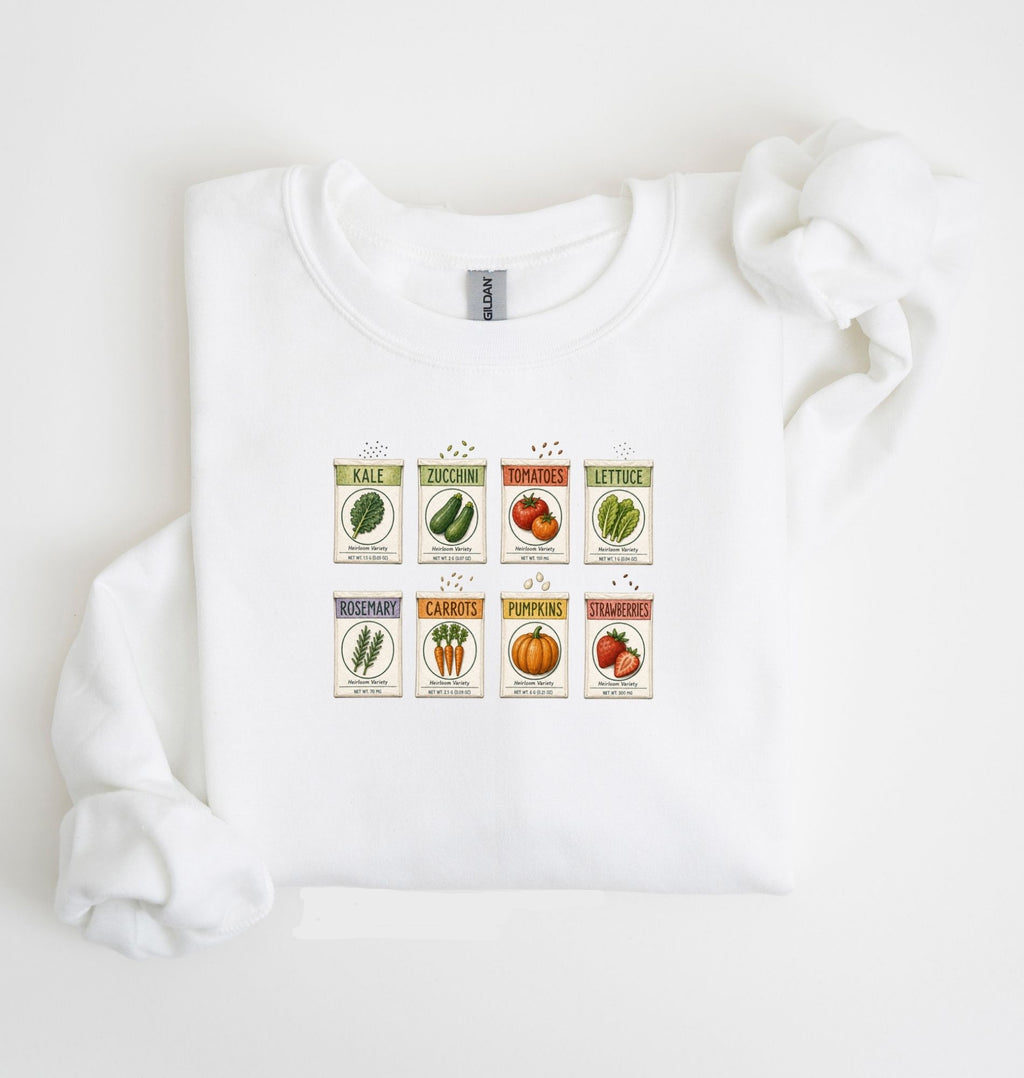 Flat lay of an white vintage seed packet garden sweatshirt with heirloom vegetable and herb illustrations gardener gift on a white background 