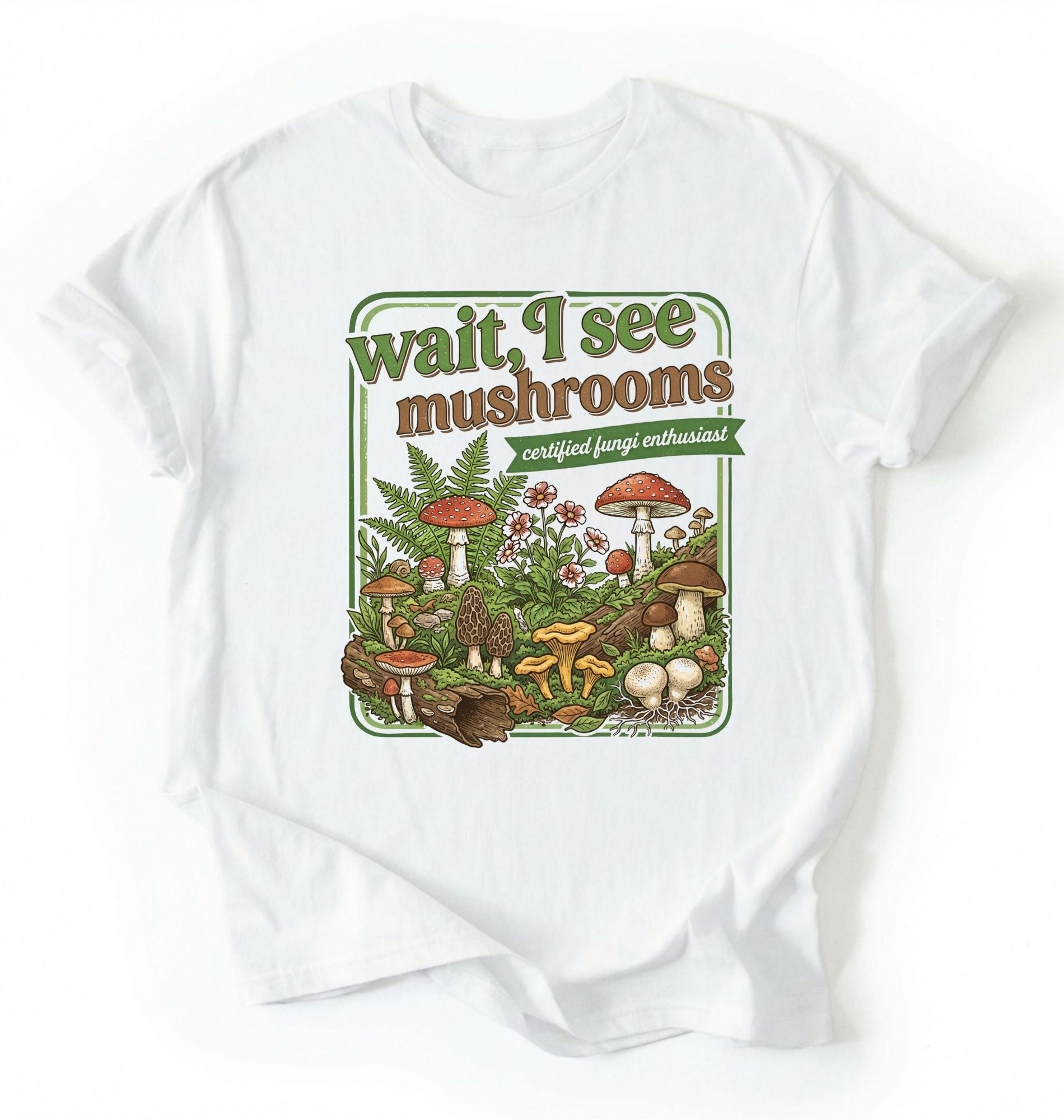 Flat lay of a white t-shirt featuring illustrated mushrooms and plants with text reading “Wait I See Mushrooms Certified Fungi Enthusiast on a white background