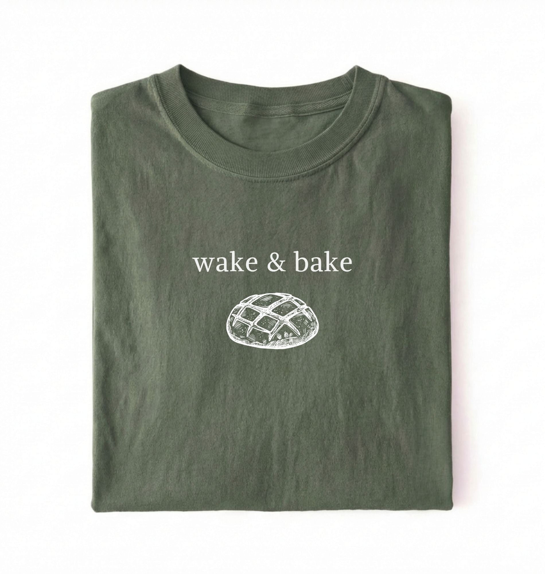 Flat lay of a moss Funny wake and bake bread shirt perfect for bakers bread lovers and home baking enthusiasts on a white background