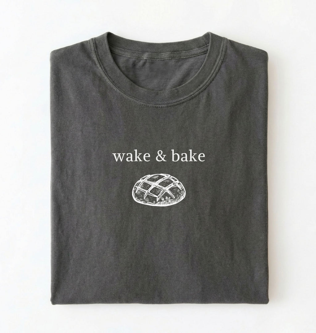 Flat lay of a pepper Funny wake and bake bread shirt perfect for bakers bread lovers and home baking enthusiasts on a white background