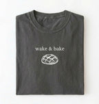 Flat lay of a pepper Funny wake and bake bread shirt perfect for bakers bread lovers and home baking enthusiasts on a white background