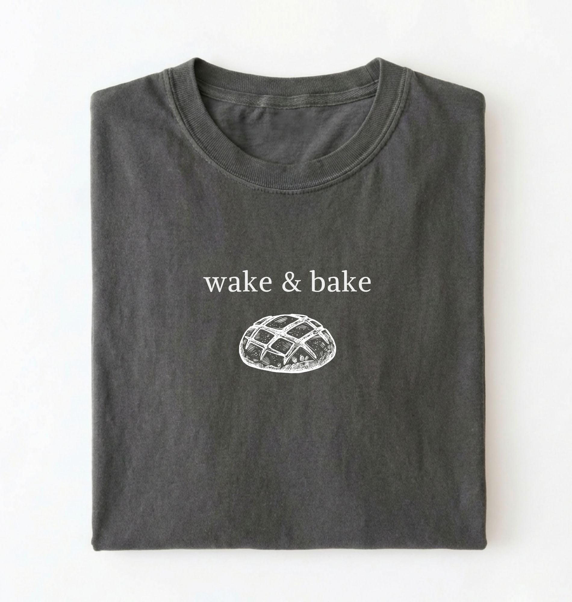 Flat lay of a pepper Funny wake and bake bread shirt perfect for bakers bread lovers and home baking enthusiasts on a white background