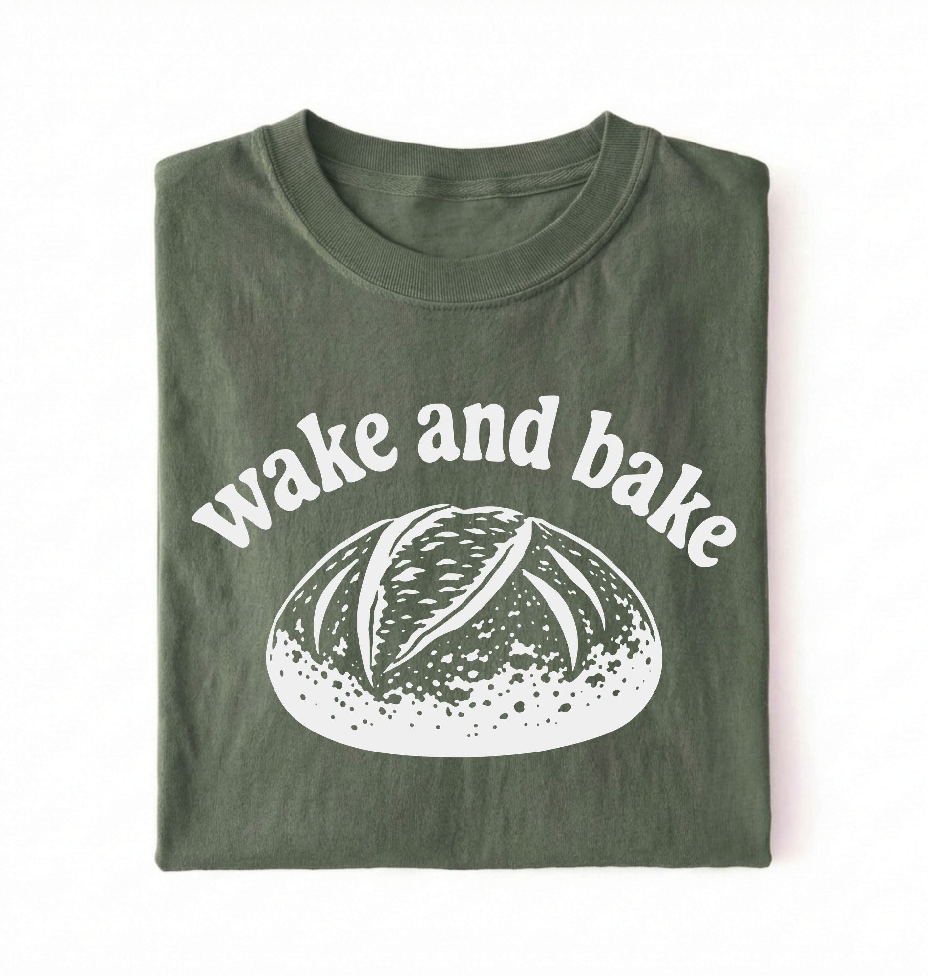 Flat lay of a Funny wake and bake bread shirt with rustic loaf illustration on green tee on a white background