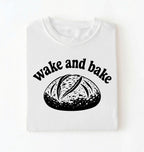 Flat lay of a Funny wake and bake bread shirt with rustic loaf illustration on white tee on a white background