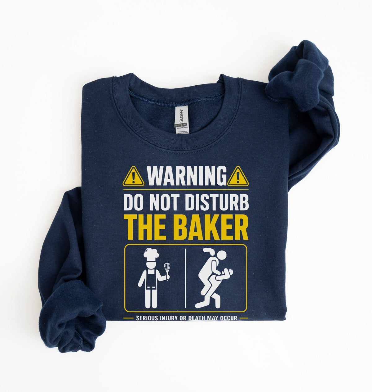 A navy blue long-sleeve t-shirt with a graphic print on the front that reads 'WARNING DO NOT DISTURB THE BAKER' with yellow warning icons and a cartoon baker icon, shown on a plain white background.