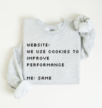 A light heather gray long-sleeve sweatshirt with black pixel-style text reading 'WEBSITE: WE USE COOKIES TO IMPROVE PERFORMANCE ME: SAME', laid flat on a white background with the sleeves styled around the edges.