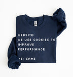 A navy blue crewneck sweatshirt with white pixelated text reading 'WEBSITE: WE USE COOKIES TO IMPROVE PERFORMANCE 4E: SAME', folded neatly on a white background.