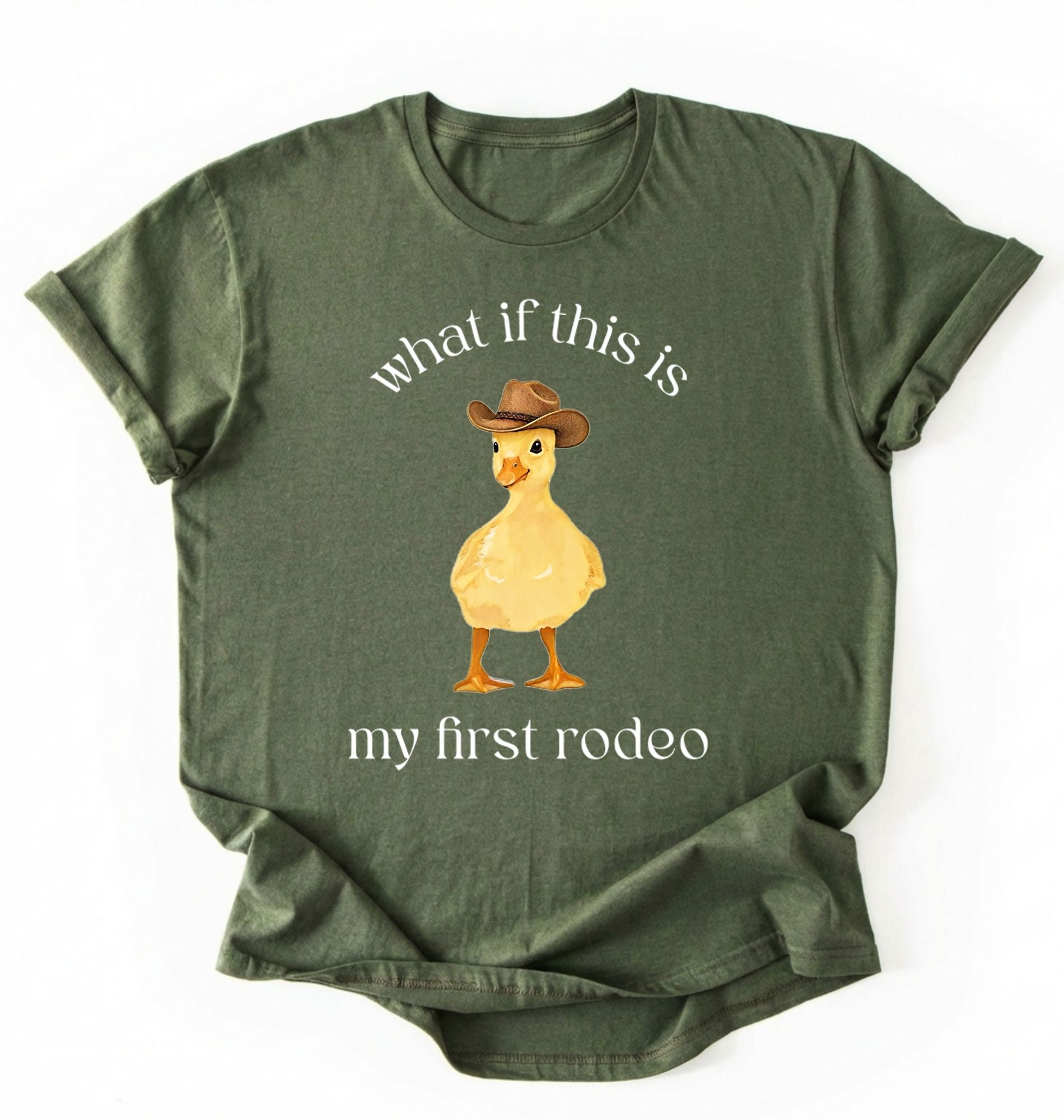 Flat lay of a Moss Military Green what if this is my first rodeo shirt brown funny cowboy duck t shirt western humor gift on a white background 