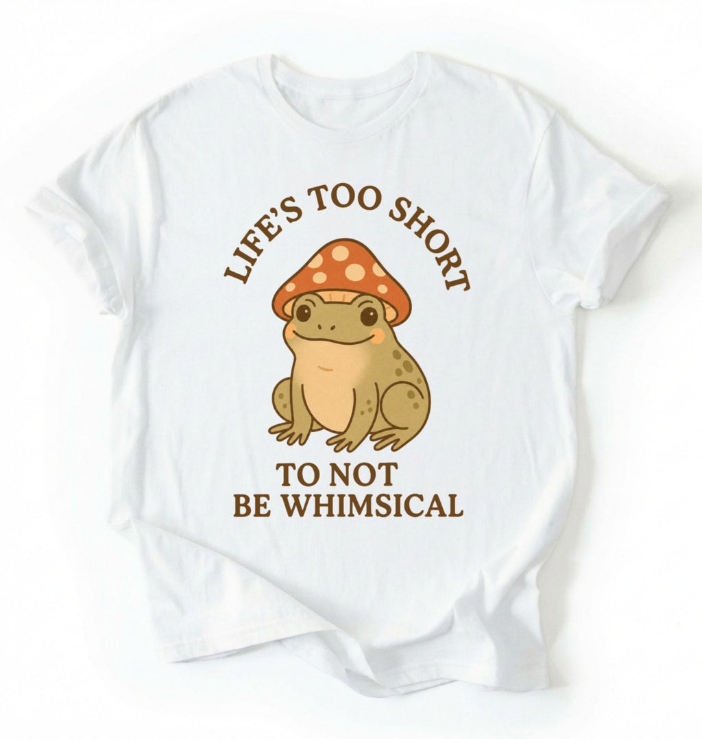 Flat lay of a white whimsical frog shirt cream cute mushroom frog t shirt cottagecore aesthetic gift design on a white background 