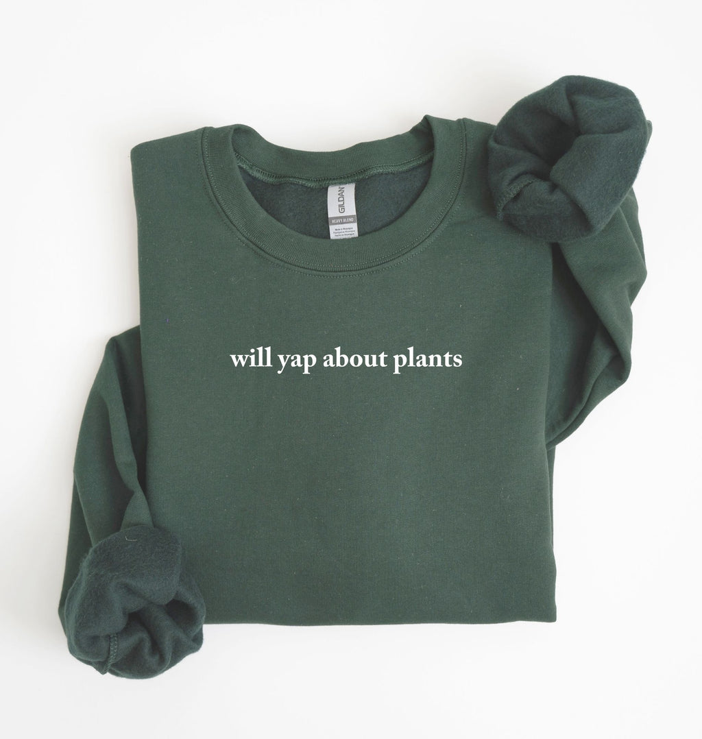 Flat lay of a forestgreen cozy crewneck sweatshirt on a white background with text reading “Will yap about plants centered on the front  