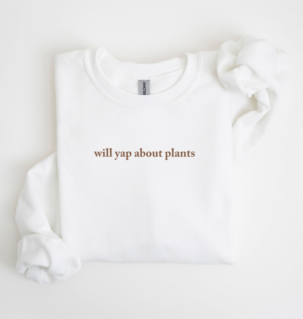 Flat lay of a white cozy crewneck sweatshirt on a white background with text reading “Will yap about plants centered on the front  