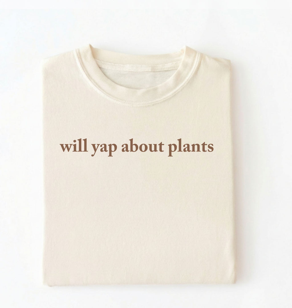 Flat lay of a ivory cozy crewneck t-shirt on a white background with text reading “Will yap about plants centered on the front 