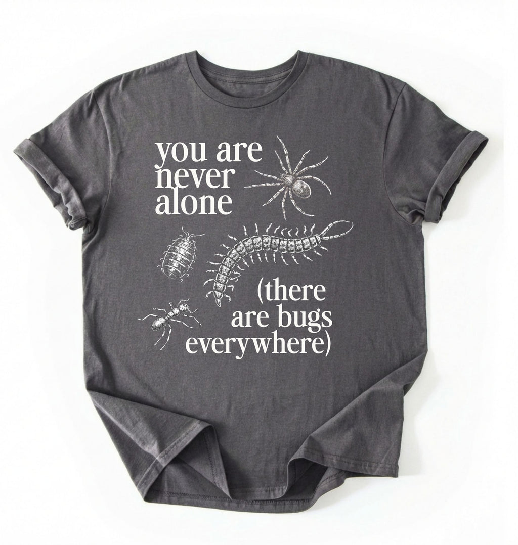 Flat lay of a Charcoal t-shirt featuring illustrated insects including a spider and centipede with text reading “You Are Never Alone (there are bugs everywhere). Funny bug shirt insect illustrations design perfect gift for science lovers 