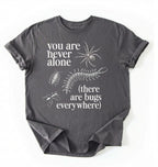 Flat lay of a Charcoal t-shirt featuring illustrated insects including a spider and centipede with text reading “You Are Never Alone (there are bugs everywhere). Funny bug shirt insect illustrations design perfect gift for science lovers 