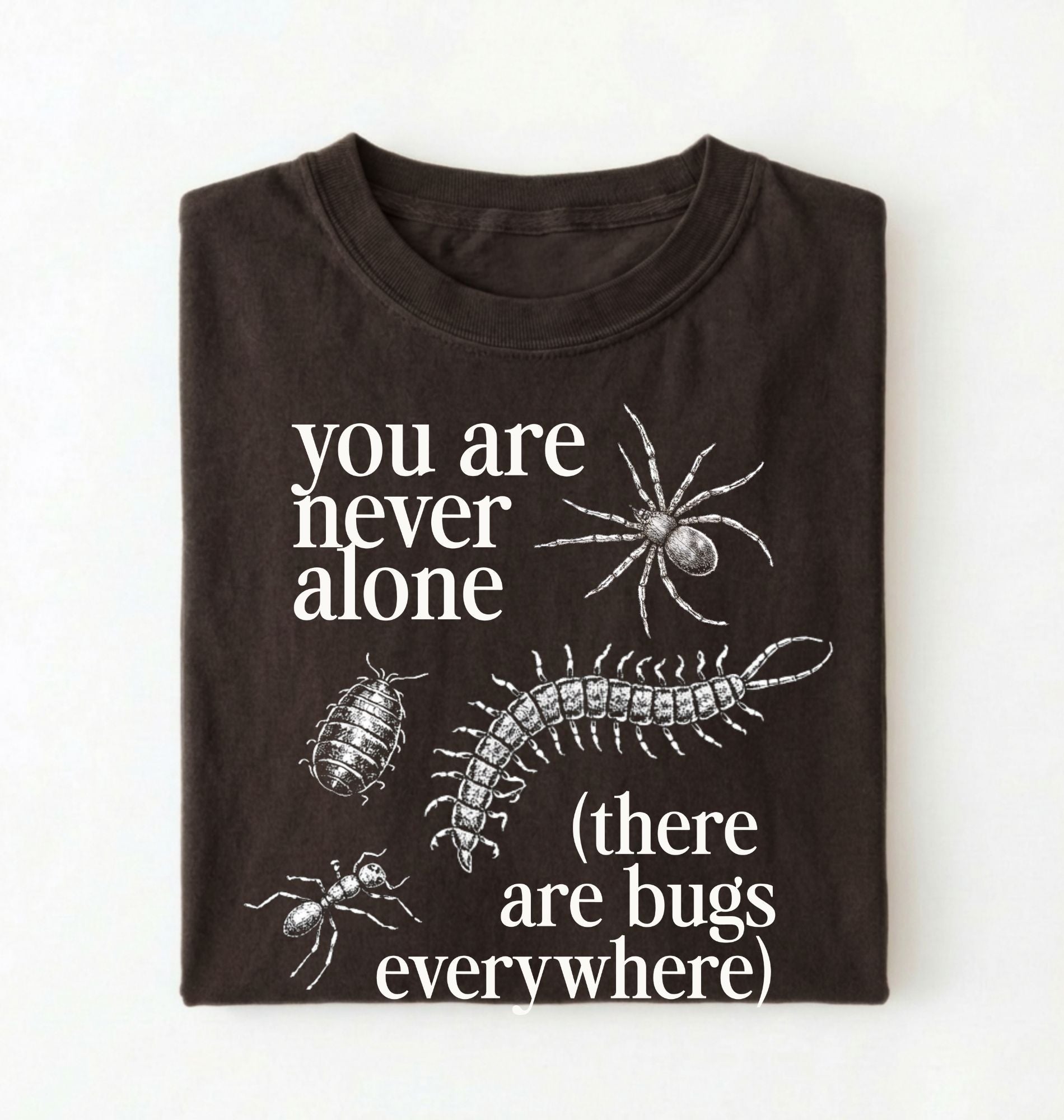 Flat lay of a darkchocolate t-shirt featuring illustrated insects including a spider and centipede with text reading “You Are Never Alone (there are bugs everywhere). Funny bug shirt insect illustrations design perfect gift for science lovers 
