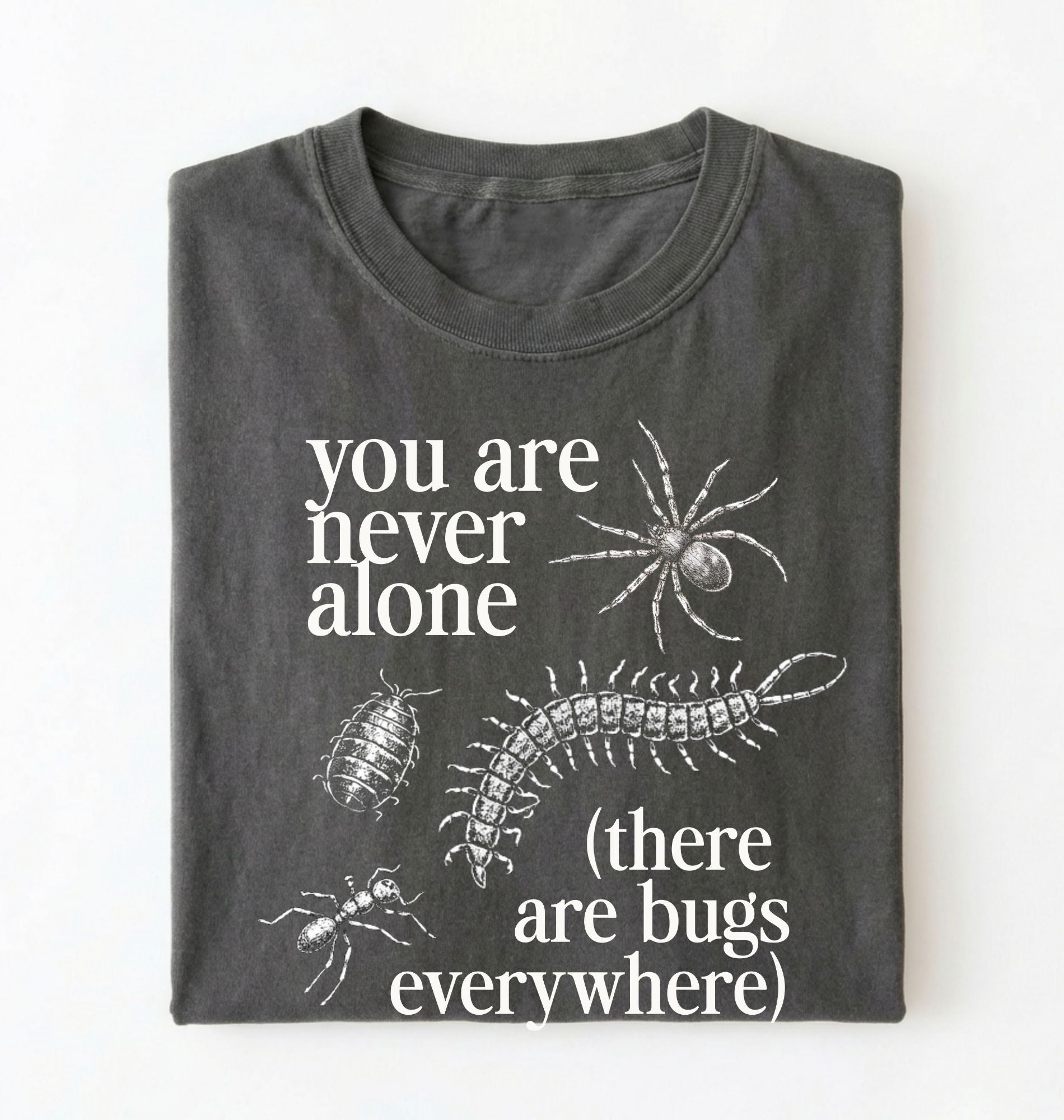 Flat lay of a pepper t-shirt featuring illustrated insects including a spider and centipede with text reading “You Are Never Alone (there are bugs everywhere). Funny bug shirt insect illustrations design perfect gift for science lovers 