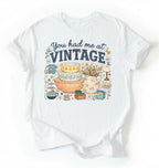 Flat lay of a white you had me at vintage shirt white retro thrift aesthetic antique lover gift on a white background 